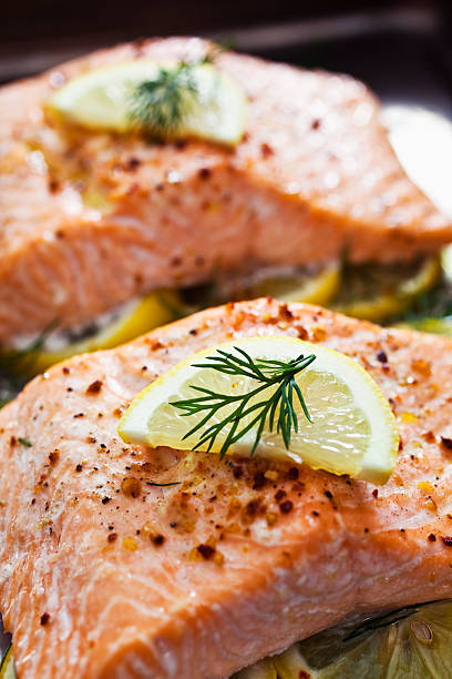 Baked Salmon Baked Salmon on a bed of lemon slices. Shot on a baking sheet. Selective focus. dill photos stock pictures, royalty-free photos & images