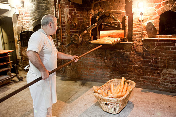 padeiro fazendo pão de forno na antiguidade padaria - idosos aquecedor imagens e fotografias de stock