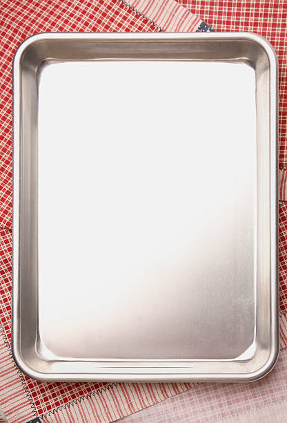 Baking / Cookie Sheet with copyspace A shallow baking pan or cookie sheet over colorful cloth napkins. baking sheet stock pictures, royalty-free photos & images