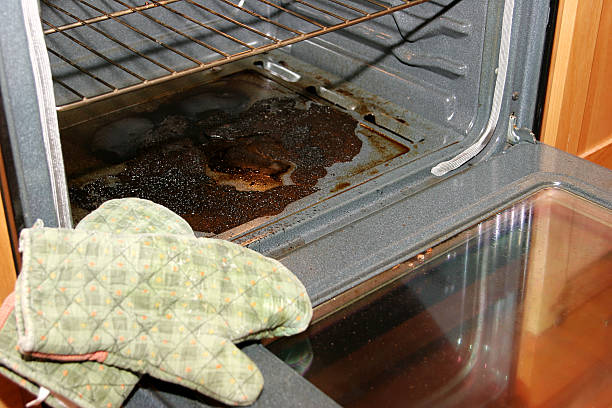 Baking Disaster Badly burnt oven with oven mits in forefront unhygienic stock pictures, royalty-free photos & images