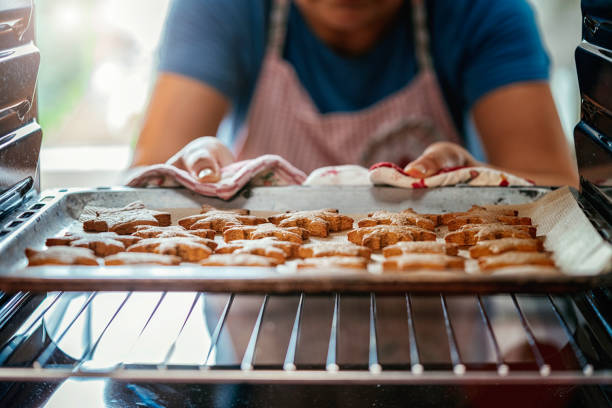 gingerbread koekjes in de oven bakken - gebakken in de oven stockfoto's en -beelden