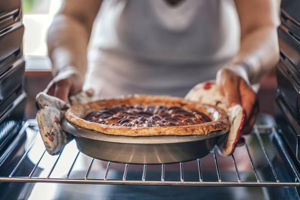 de pastei van de pecannoot in de oven bakken voor vakantie - gebakken in de oven stockfoto's en -beelden