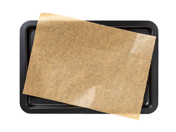 Baking sheet with brown parchment paper isolated on a white background. Empty oven tray for baking and roasting. Rectangular baking pan for food design. Nonstick kitchen utensils. Baking sheet with brown parchment paper isolated on a white background. Empty oven tray for baking and roasting. Rectangular baking pan for food design. Nonstick kitchen utensils. Top view. baking sheet stock pictures, royalty-free photos & images