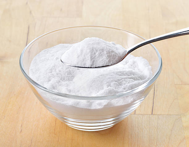 Baking soda in a glass bowl with one spoon stock photo