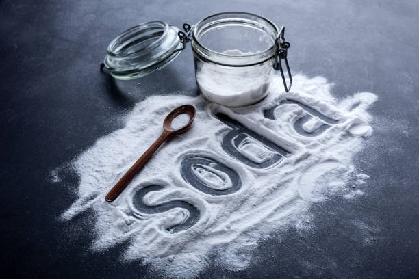 baking soda scattered from a glass jar on a dark background stock photo