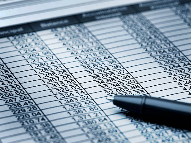 Balance Sheet Close up of paper with numbers and a pen with a blue hue accounting ledger stock pictures, royalty-free photos & images