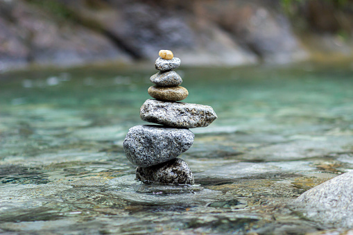 Balanced stones forming a natural sculpture in a river or waterfall