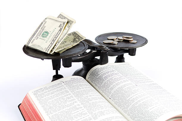 Balancing Money and Bible stock photo