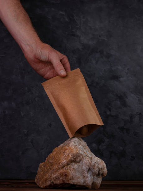 équilibrage sac sac maquette pierre naturelle. paquet blanc de papier kraft avec le fond foncé de grains de café. équilibre flottant - the game photos et images de collection