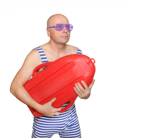 bald man dressed in retro style swimwear holding red surf isolated on white background. summer sports and activities theme. - bald beach imagens e fotografias de stock