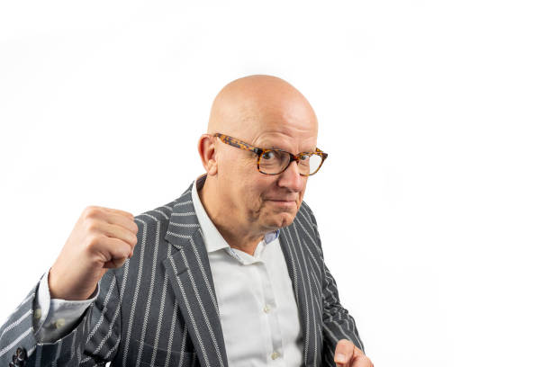 Bald middle-aged man with glasses and striped jacket is enthusiastic and makes "yes" gesture with a clenched fist stock photo