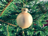 istock A ball as decoration on a green Christmas tree. 1383133491
