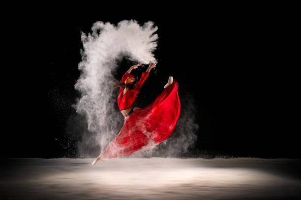 Ballerina in red dress, dancing with dust stock photo