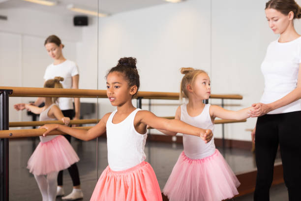 Ballet trainer teaching two little girls stock photo