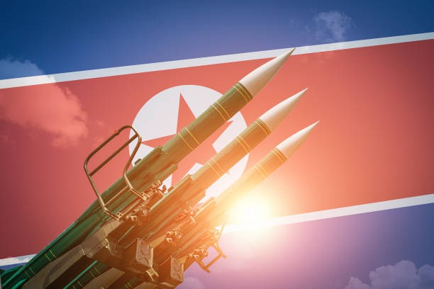 북한 국기 배경에 탄도 미사일이나 로켓. 대량 학살의 무기와 핵전쟁의 위협 - north korea 뉴스 사진 이미지