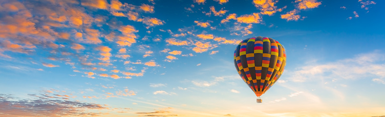 balloon and sky,Multicolored hot air balloons at sunset sky for your billboard of a travel agency or wide banner, brigth colors and soft sun light.