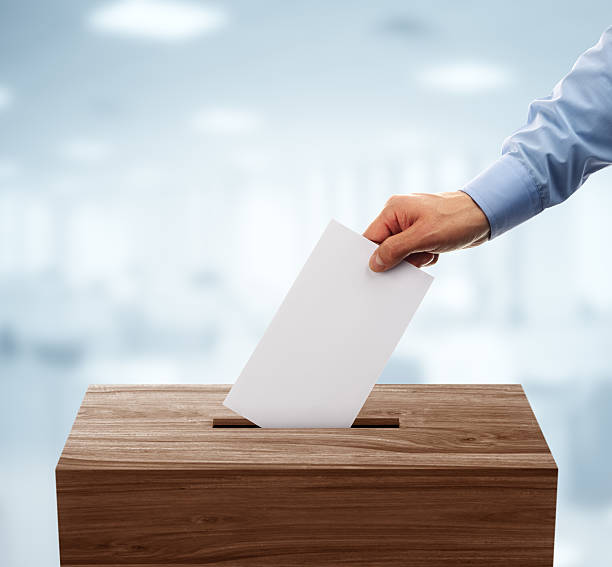 Ballot box Ballot box with person casting vote on blank voting slip ballot box stock pictures, royalty-free photos & images