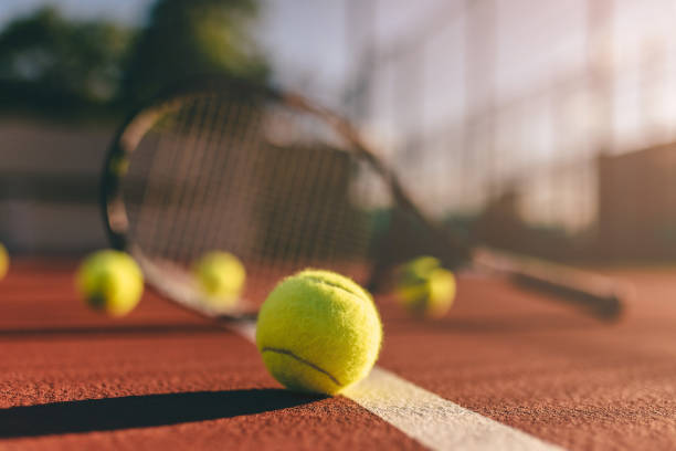 Balls and racket on tennis court. stock photo