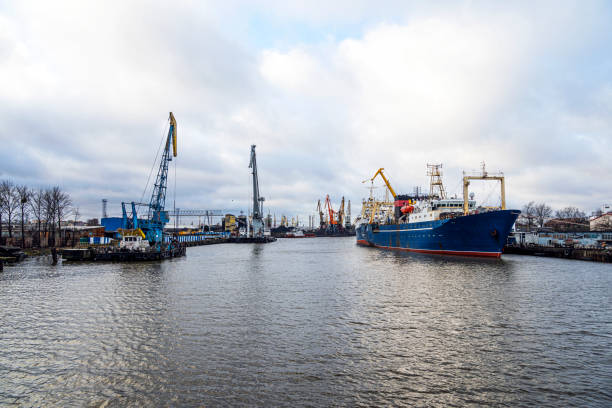 Baltic Sea. Many tall cargo cranes barges and ships, stand on the banks of River. stock photo