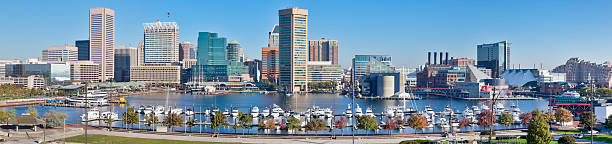 Baltimore Inner Harbor Panorama - Trees and Skyscrapers Panoramic image of Baltimore's Inner Harbor on a sunny autumn morning. Trees on the south rim of the harbor taking on their fall folliage under a clear blue sky. inner harbor baltimore stock pictures, royalty-free photos & images