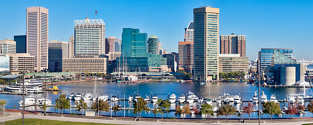 Baltimore Inner Harbor Skyline and Boats Early morning sunshine on Baltimore's Inner Harbor with its many buildings and boats docked in the marina. inner harbor baltimore stock pictures, royalty-free photos & images