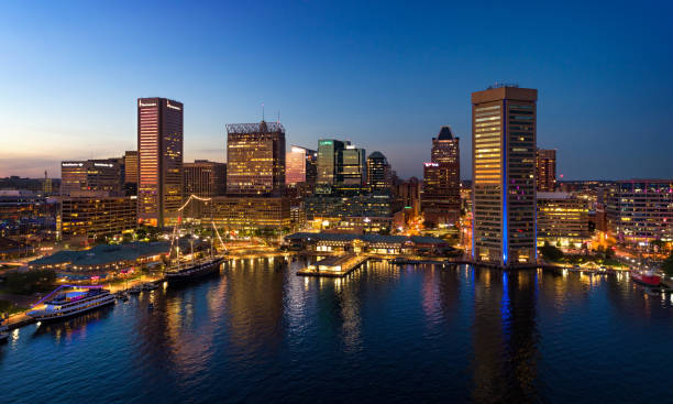 Baltimore Skyline And Inner Harbor Aerial At Dusk Downtown Baltimore skyline aerial at dusk, with Inner Harbor in the foreground. baltimore maryland stock pictures, royalty-free photos & images