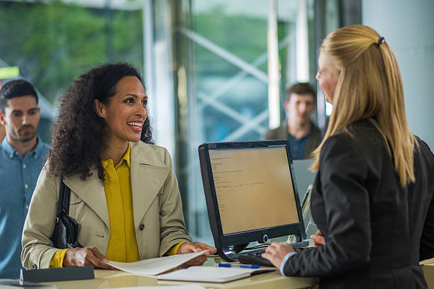 Bank Counter Customer holding document and smiling while bank teller serving. Bank Teller stock pictures, royalty-free photos & images