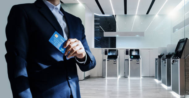 Bank manager and credit card in hand, business man standing confidently with pride in modern financial, futuristic, technology and banking network connection Bank manager and credit card in hand, business man standing confidently with pride in modern financial, futuristic, technology and banking network connection banks and atms stock pictures, royalty-free photos & images