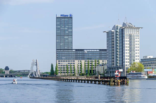 Banks of the River Spree with the high-Rise at the Elsenbruecke bridge and Molecule Man in Berlin stock photo