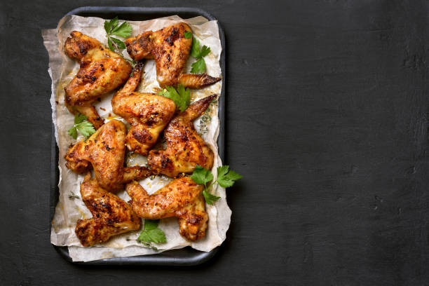 Barbecue chicken wings Roasted chicken wings on baking tray over dark background with copy space, top view baking sheet stock pictures, royalty-free photos & images