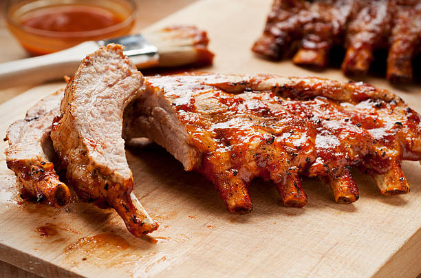 Barbecue Ribs Barbecue ribs with sauce on a cutting board. pork stock pictures, royalty-free photos & images