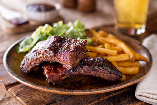 Barbecued Ribs with Fries and Salad A plate of delicious barbecued ribs with french fries and salad. barbecue meal photos stock pictures, royalty-free photos & images