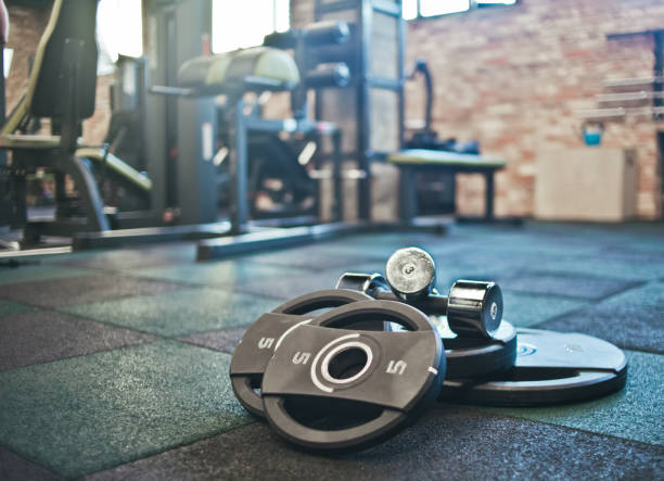 Barbell, dumbbells lie on the floor against the background of the gym. Free weight training. Functional powerful training stock photo