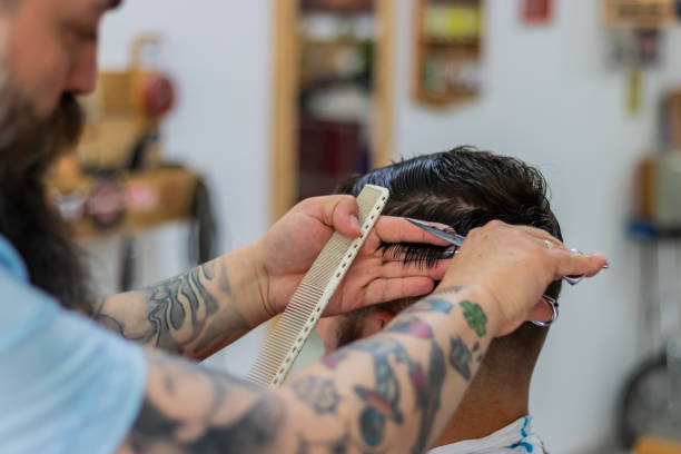 Barber holding hair between fingers stock photo