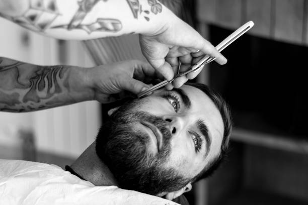 Barber shaving young man stock photo
