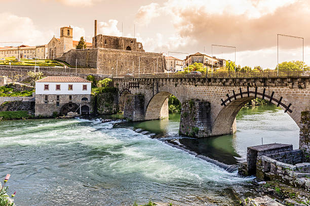 Barcelos bridge in Portugal over river Cávado Barcelos romanesque bridge in Portugal over the river Cávado. This panoramic view of an historic site with archeological findings towards the left side of the bridge, and a mill along the river still working today. barcelos stock pictures, royalty-free photos & images
