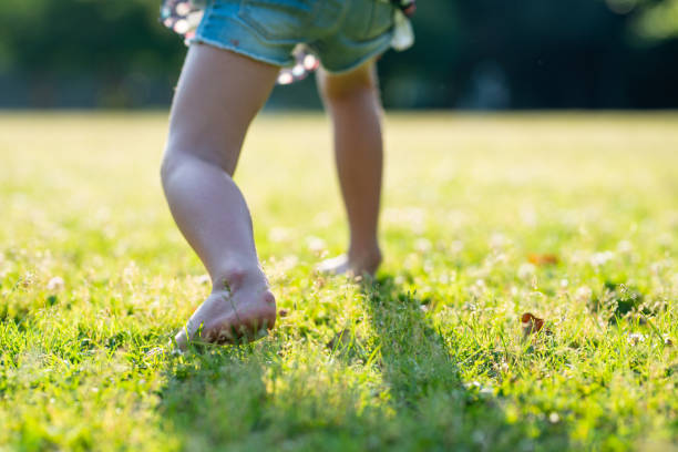 裸足の子供の足は牧草地で遊んで - スタート ストックフォトと画像