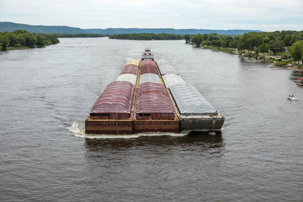 Barge on the Mississippi River Towboat pushing the barge with freight on the Mississippi River midsummer. barge stock pictures, royalty-free photos & images