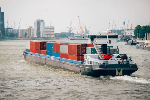 Barge with cargo containers A long barge in a river carrying cargo containers. barge stock pictures, royalty-free photos & images