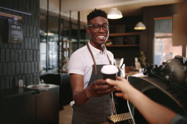 barista bedienen van klanten binnen een coffeeshop - africa cup stockfoto's en -beelden