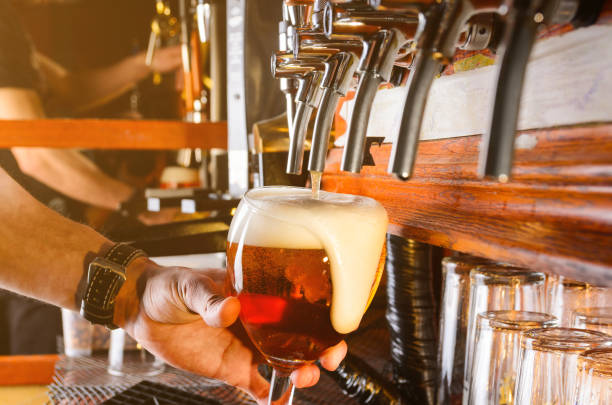 Barman is serving beer from faucet stock photo
