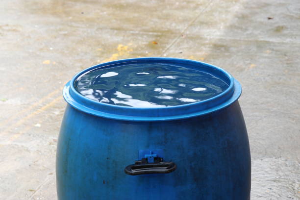 barrel of water filled upto its top surface from rain water from roof. rain water harvesting or conservation concept - save water bucket stockfoto's en -beelden
