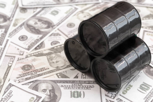 Barrels of oil against the background of American dollars stock photo