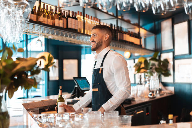 Bartender holding a bottle of wine from the bar Winery, Men, Bar - Drink Establishment, Bartender, Red Wine bar drink establishment photos stock pictures, royalty-free photos & images