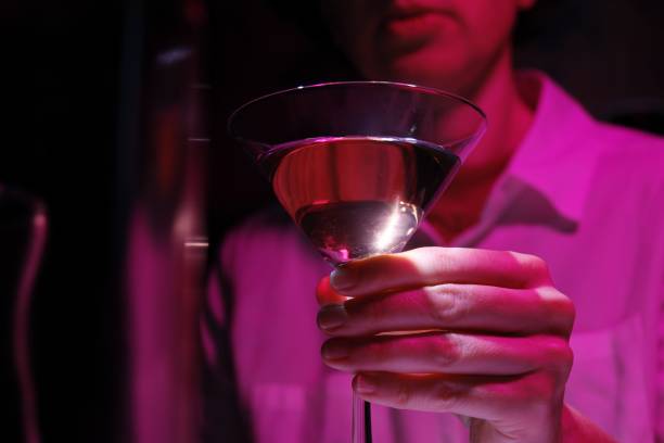 Bartender is making drinks in vibrant pink light stock photo