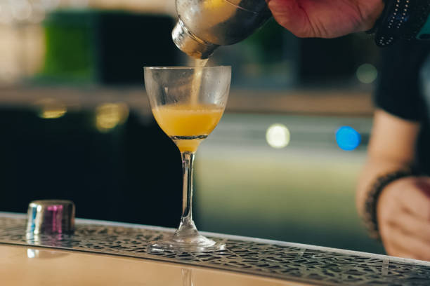 a Bartender pouring cocktail at bar counter