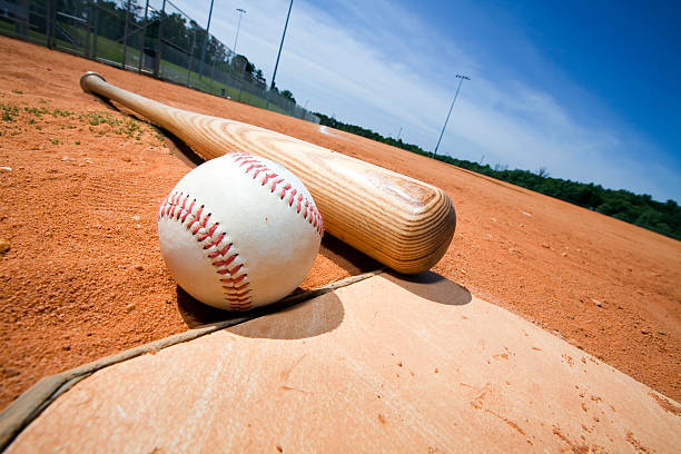 Baseball and Bat on Home Plate Baseball and bat on home plate of a ballpark sports bat stock pictures, royalty-free photos & images