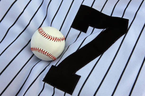 Baseball Jersey A baseball on a pinstriped jersey with the number seven. baseball uniform stock pictures, royalty-free photos & images