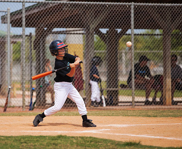 Baseball Nine year old swinging a bat at a baseball. batting sports activity stock pictures, royalty-free photos & images
