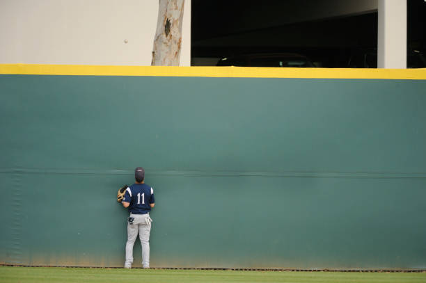 A baseball player searching desperately for his ball A baseball player can only watch as the ball clears the wall for a home run. home run stock pictures, royalty-free photos & images